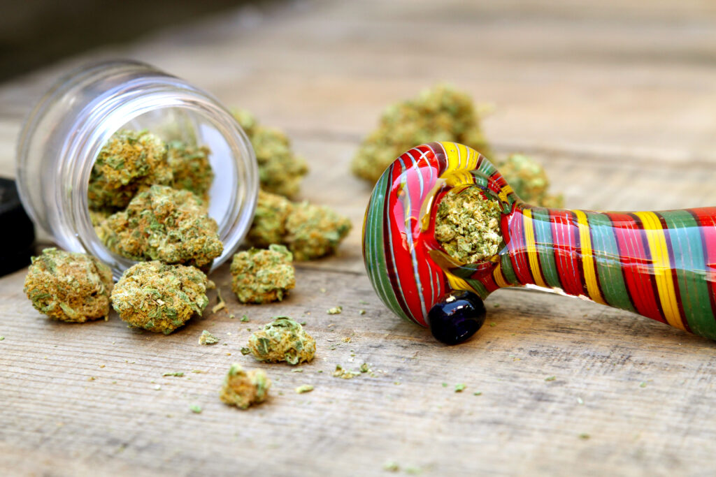 a setting of a glass pipe, cannabis, and a bowl already served.
