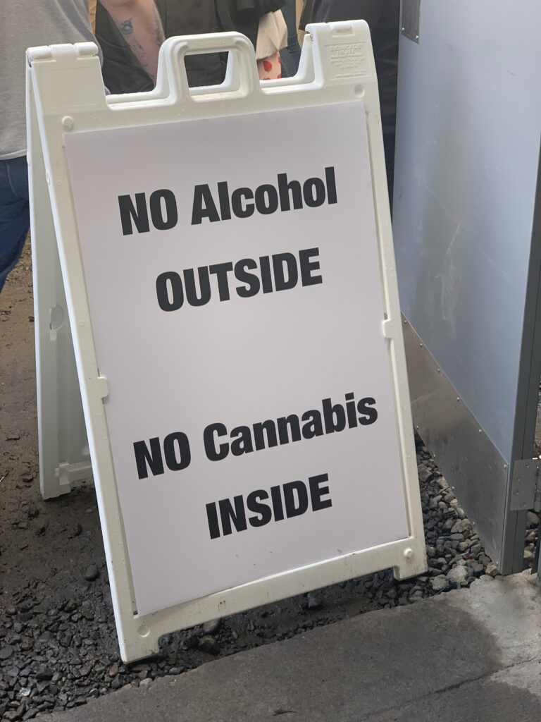 a crowd control sign designating areas of cannabis smoking and liquor drinking